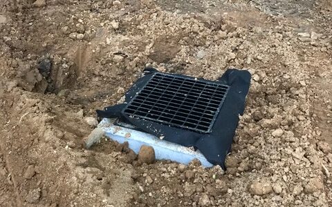 Custom-designed sewer grate by Del Val Septics for a residential project.