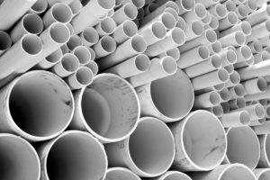 A collection of white schedule 40 4-inch PVC pipes, showcasing the standard materials used in residential sewer line replacement projects and raising questions about the time required for completion